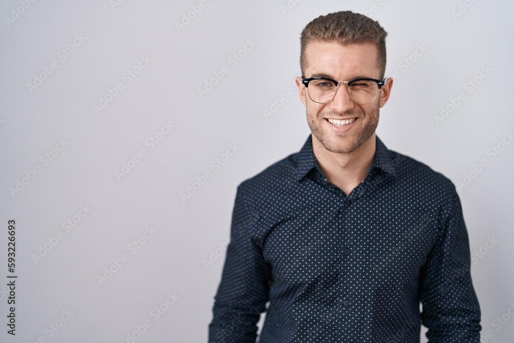 Young caucasian man standing over isolated background winking looking at the camera with sexy expression, cheerful and happy face. Young caucasian man standing over isolated background winking looking at the camera with sexy expression, cheerful and happy face.