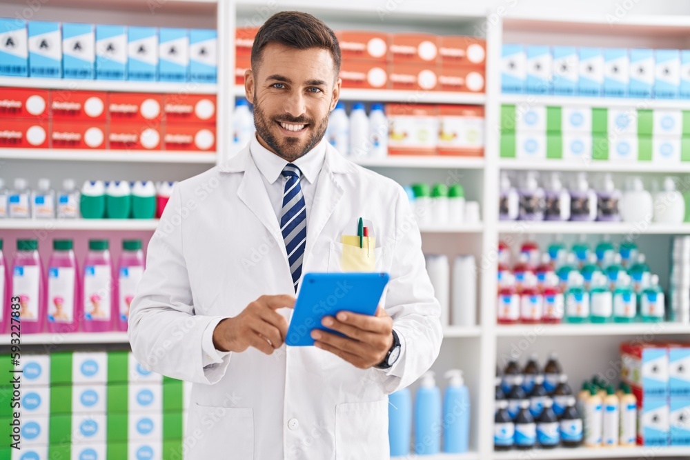 Young hispanic man pharmacist using touchpad working at pharmacy Young hispanic man pharmacist using touchpad working at pharmacy