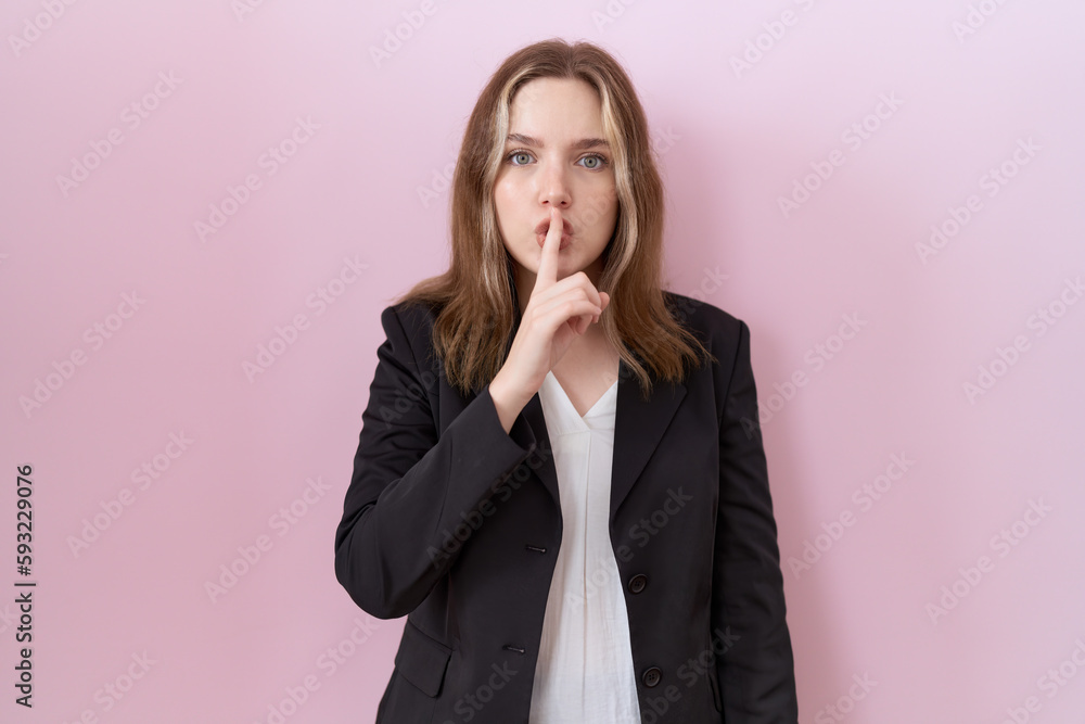 Young caucasian business woman wearing black jacket asking to be quiet with finger on lips. silence and secret concept. Young caucasian business woman wearing black jacket asking to be quiet with finger on lips. silence and secret concept.
