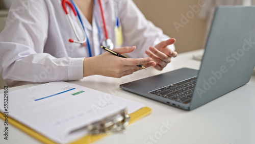 Young beautiful hispanic woman doctor having video call at clinic