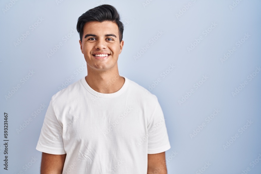 Hispanic man standing over blue background with a happy and cool smile on face. lucky person. Hispanic man standing over blue background with a happy and cool smile on face. lucky person.