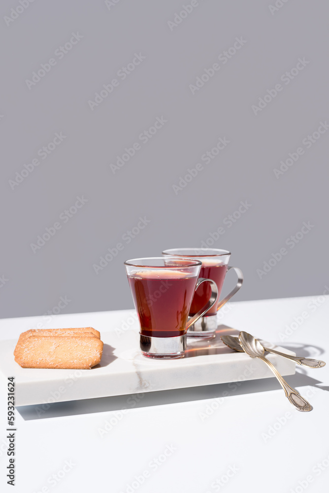 Té rojo con galletas sobre mármol y fondo gris Té rojo con galletas sobre mármol y fondo gris