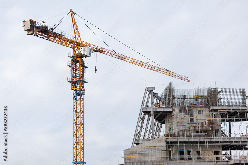 Construction of a large concrete building. Construction crane on the background of the sky. Construction site. Construction of a large concrete building. Construction crane on the background of the sky. Construction site.