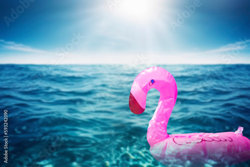 Inflatable big pink flamingo in the transparent turquoise sea. holidays background concept with copy space. trendy summer concept © annebel146