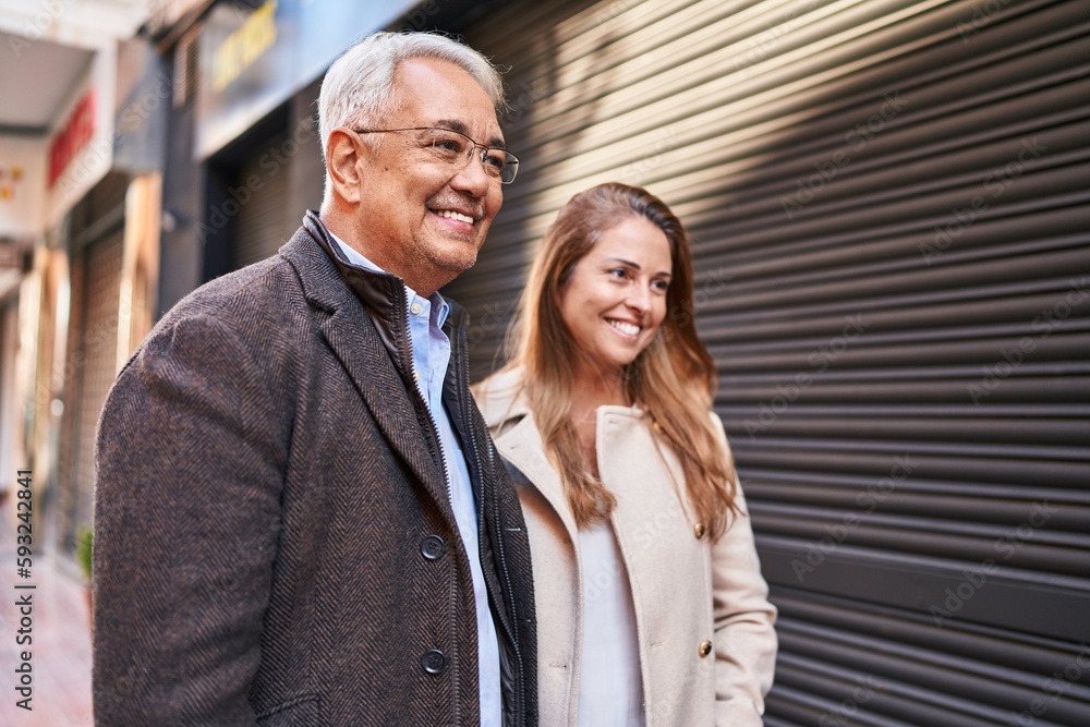 Middle age man and woman couple smiling confident standing together at street Middle age man and woman couple smiling confident standing together at street