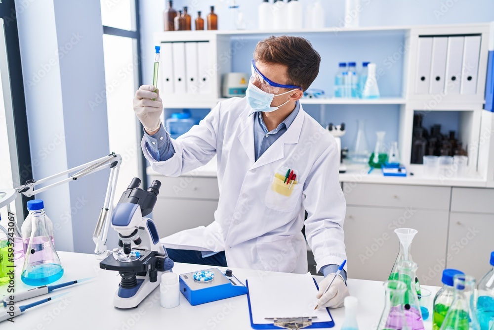 Young man scientist wearing medical mask working at laboratory Young man scientist wearing medical mask working at laboratory