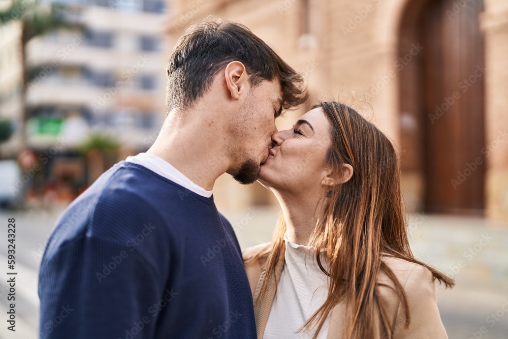Mand and woman couple standing together kissing at street Mand and woman couple standing together kissing at street