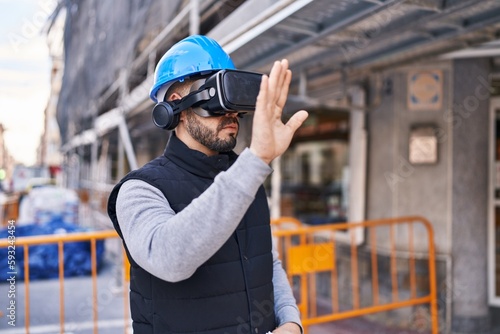 Young latin man architect using virtual reality glasses at street