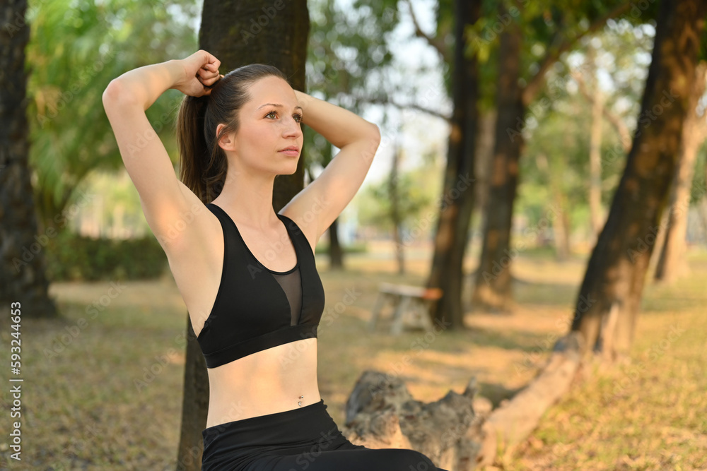 Young sportswoman leaning on tree trunk, resting after running in the park. Healthy lifestyle, sport, wellness concept Young sportswoman leaning on tree trunk, resting after running in the park. Healthy lifestyle, sport, wellness concept