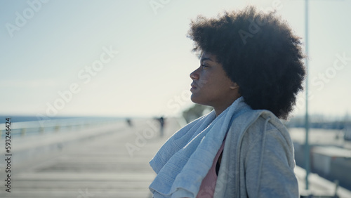 African american woman wearing sportswear leaning on balustrade at seaside © Krakenimages.com