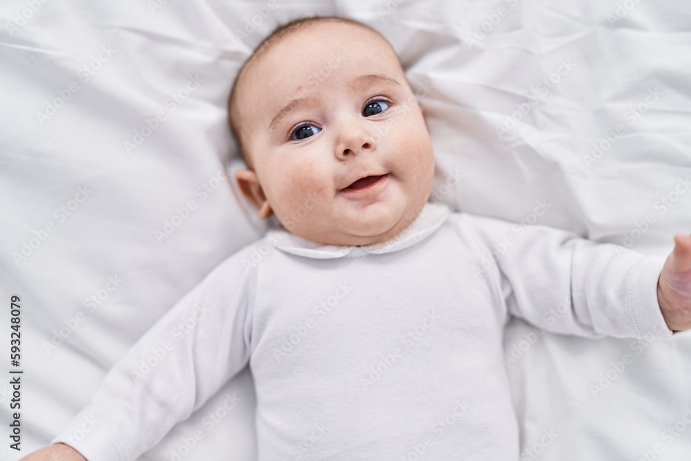 Adorable baby smiling confident lying on bed at bedroom Adorable baby smiling confident lying on bed at bedroom