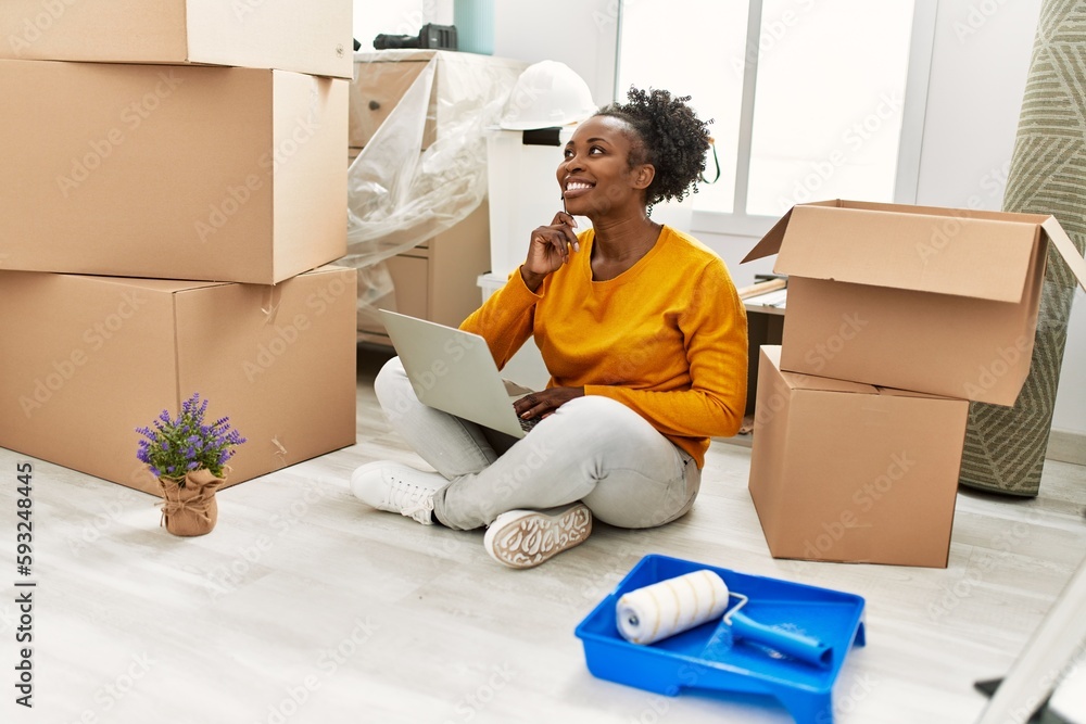 African american woman using laptop sitting on floor at new home African american woman using laptop sitting on floor at new home