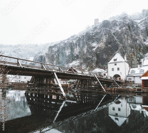 River reflecting the houses and the snow-covered mountains in the background, Kelheim, Germany