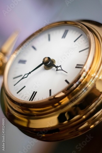 Vertical closeup of a golden pocket watch in vintage style