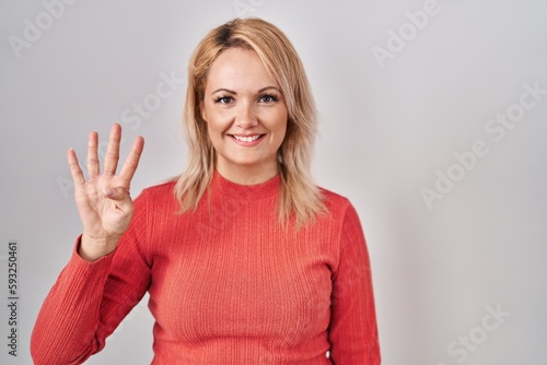 Wallpaper Mural Blonde woman standing over isolated background showing and pointing up with fingers number four while smiling confident and happy. Torontodigital.ca