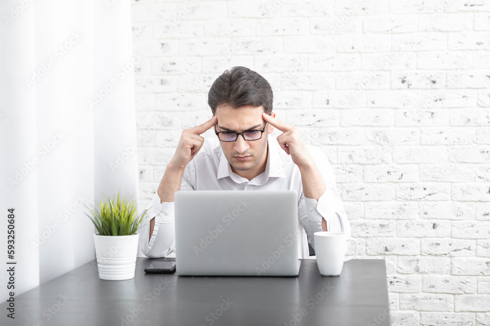 Young handsome businessman feeling bad after tiring busy work day online. Distant work concept Young handsome businessman feeling bad after tiring busy work day online. Distant work concept