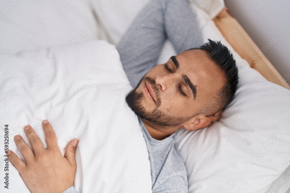 Young hispanic man lying on bed sleeping at bedroom Young hispanic man lying on bed sleeping at bedroom