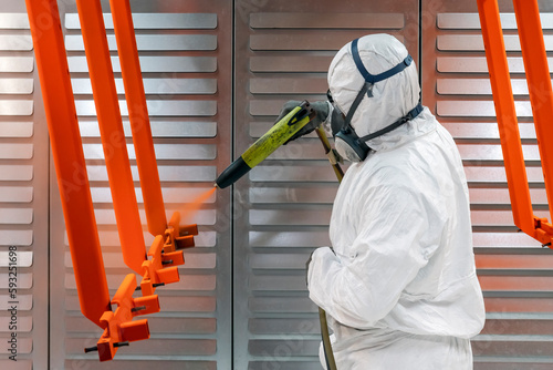 Fototapeta Naklejka Na Ścianę i Meble -  worker painting with a paint gun in a factory
