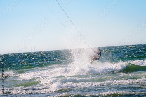Man riding a kite surfboard on bright sunny day at sea