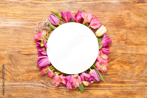 Blank card with pink flowers on wooden background
