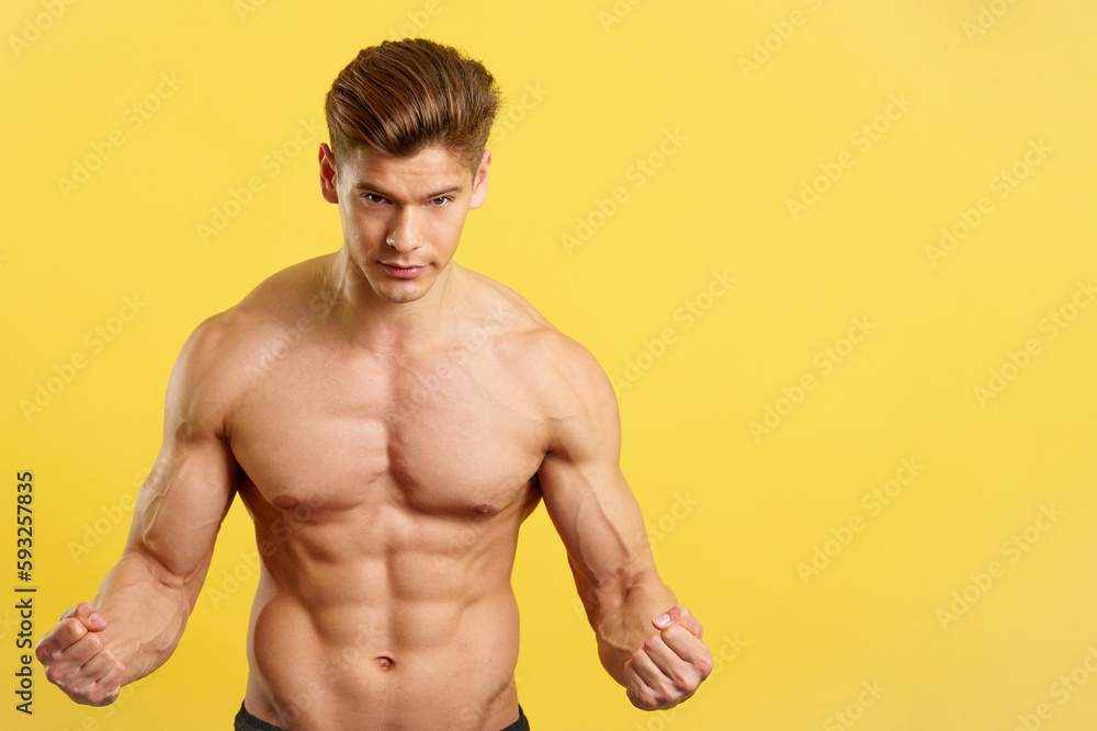 Strong man with abs looking at camera showing muscle