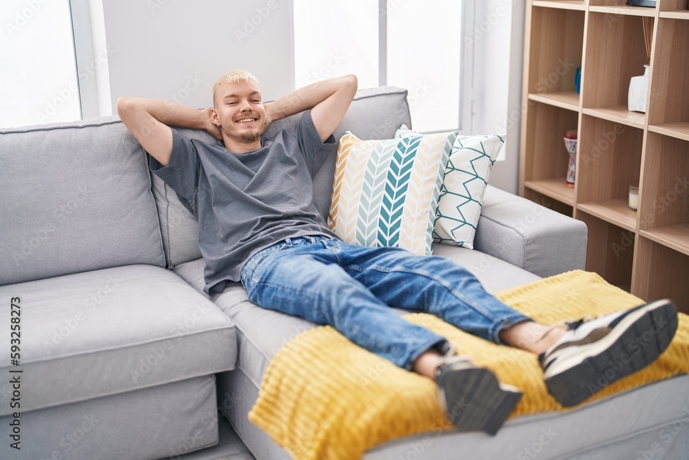Young caucasian man relaxed with hands on head lying on sofa at home Young caucasian man relaxed with hands on head lying on sofa at home