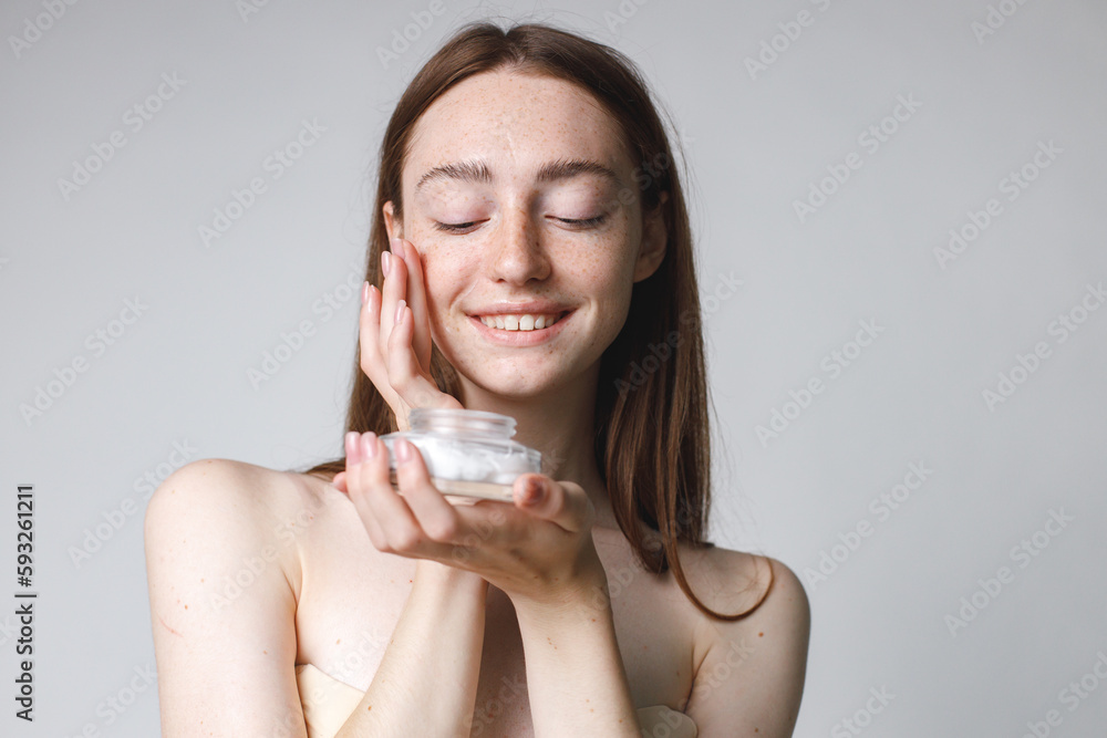 Studio portrait of a woman holding jar with face cream Studio portrait of a woman holding jar with face cream