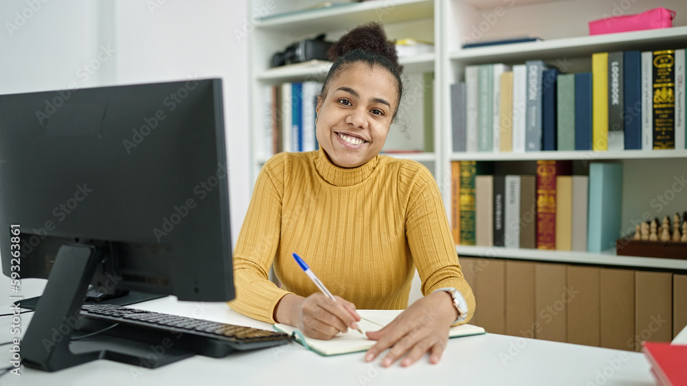 Young african american woman student taking notes at the library Young african american woman student taking notes at the library