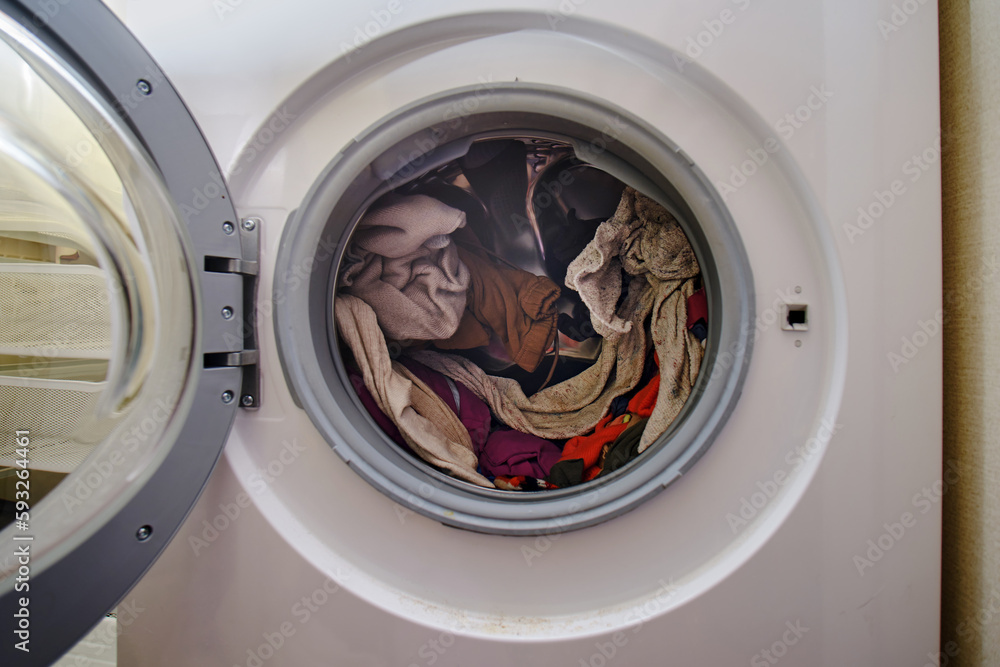 Unloading clothes from the washing machine. Removing things from the washing drum Unloading clothes from the washing machine. Removing things from the washing drum