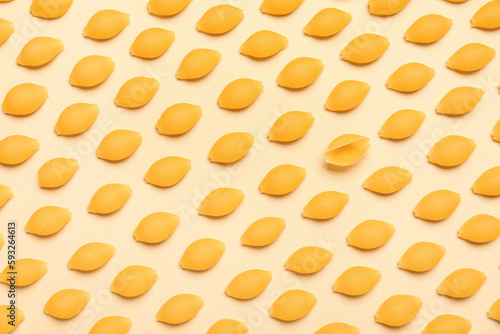 Raw conchiglie pasta on yellow background photo