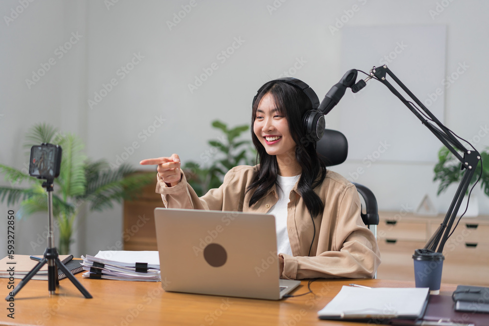 Female podcaster use smartphone and speaking with audience on microphone to recording video podcast Female podcaster use smartphone and speaking with audience on microphone to recording video podcast