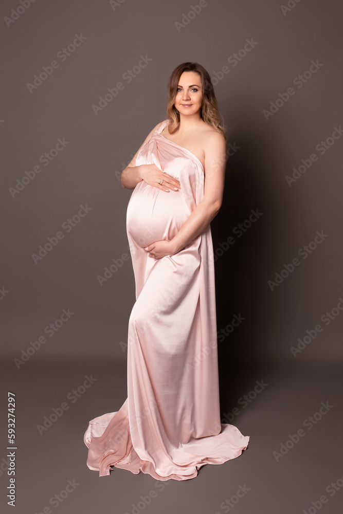 Happy pregnant girl. beautiful pregnant woman with long blond hair on a chocolate background. Pregnancy studio shooting Happy pregnant girl. beautiful pregnant woman with long blond hair on a chocolate background. Pregnancy studio shooting