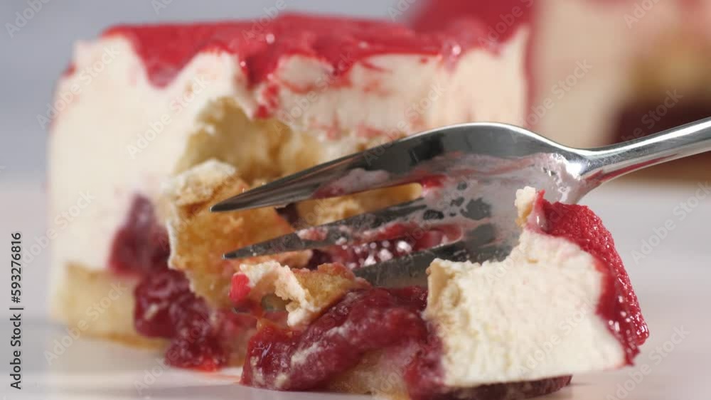 Close up of a piece of strawberry cake being cut with a dessert fork. Internal components of product layers.