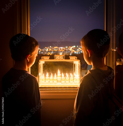 Boys looking at Hanukkah candles. It is a Jewish custom to light candles on the 8 days of Hanuka celebrating the miraculous victory over the ancient Greeks during the Second Temple period.