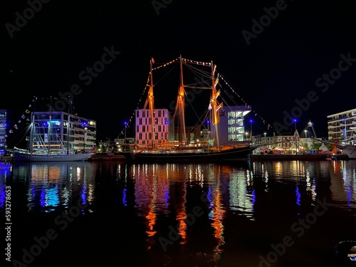 Nachtzauber am Bremerhaven: Das verträumte alte Boot und die reflektierenden Lichter © Gabriel