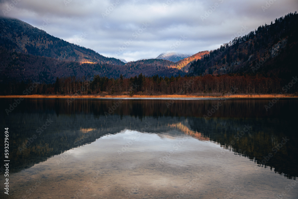Reflection of mountainsides on the surface of freshwater on a clouded autumn day