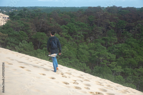 Boy walking in sand next to a forest in France