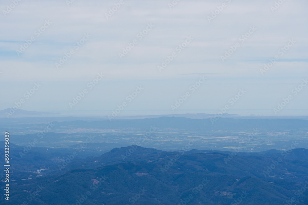 Beautiful landscape from the top of the mountain with blue sky. Views of the Valles Oriental from the Montseny mountain, Catalonia, Spain.  