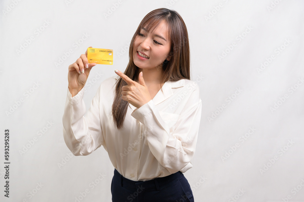 Young asian businesswoman holding credit card over white background studio, shopping and finance concept.. Young asian businesswoman holding credit card over white background studio, shopping and finance concept..