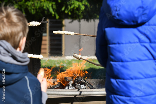 Kinder machen Stockbrot am Lagerfeuer