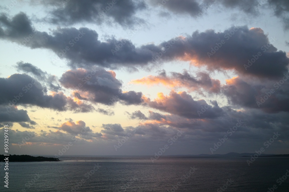 Beautiful shot of a bright cloudy sunset sky over a blue sea