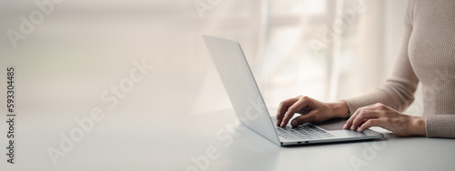 Person typing on laptop keyboard, businessman working on laptop, he is typing messages to colleagues and making financial information sheet to sum up the meeting.