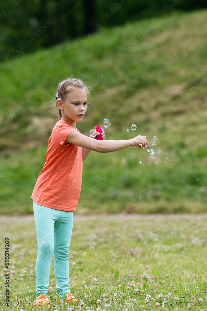 Girl with hearing aid playing with soap bubbles. Girl with hearing aid playing with soap bubbles.