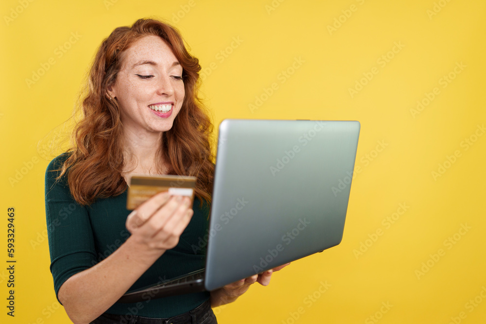 Naklejka premium Redheaded woman shopping online with a laptop