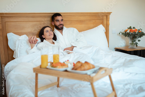 Loving Couple Hugging Enjoying Breakfast In Bed In Hotel Room