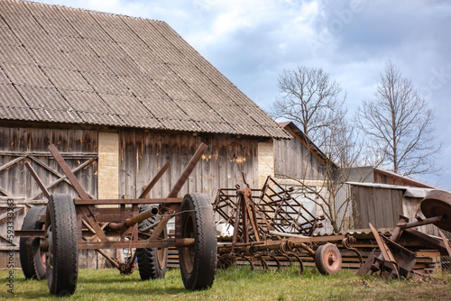 Abandoned farm equipment on the background of a wooden barn.
Porzucony sprzęt rolniczy na tle drewnianej stodoły. photo