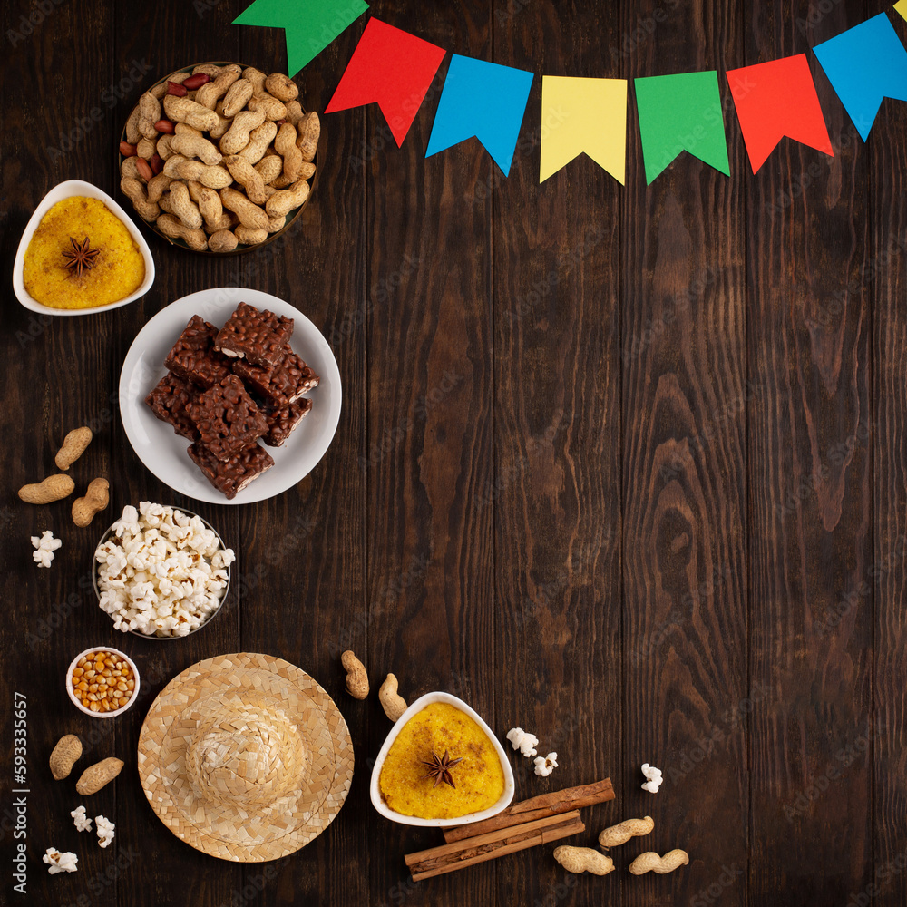 Brazilian straw hat, popcorn, peanuts and colorful flags on wooden background for Brazilian Festa Junina Summer Festival