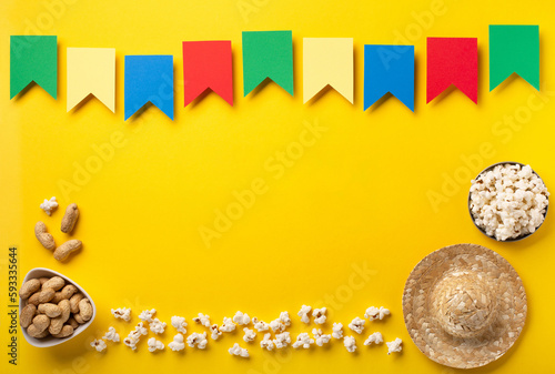 Brazilian straw hat, popcorn, peanuts and colorful flags on yellow background for Brazilian Festa Junina Summer Festival photo