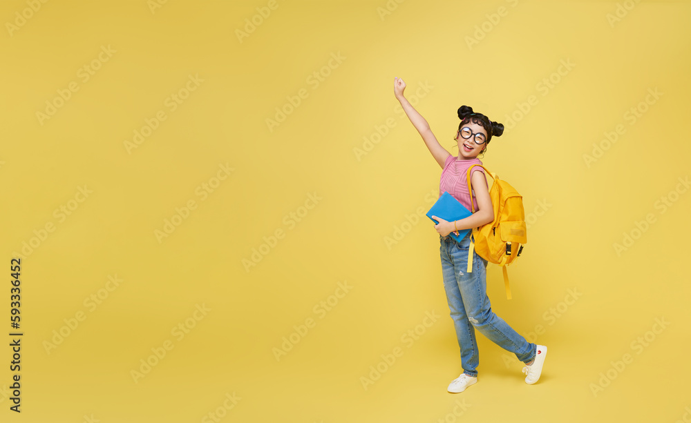Full body smiling happy cheerful teen Asian student girl hold backpack book isolated on yellow background. Education in school concept