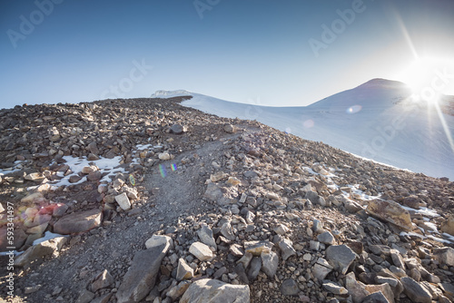 Climbing to the top of Mount Ararat covered with snow and glaciers over rocks and stones, climbing the mountain at dawn in the morning